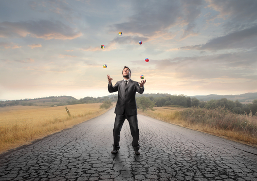 man in a suit juggling on the road